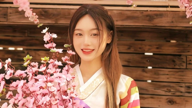 Photographie d'une femme à la beauté coréenne en handbock, vêtement traditionnel coréen avec des fleurs de cerisiers.